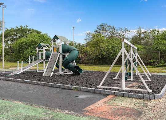 a playground with a swing set and a slide at Cypress Grove, Lauderhill, FL, 33313