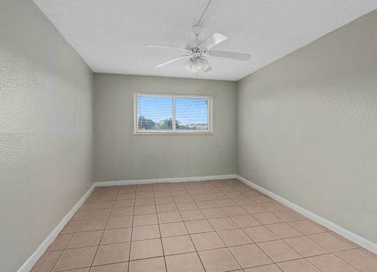 an empty room with a tile floor and a window at Cypress Grove, Lauderhill