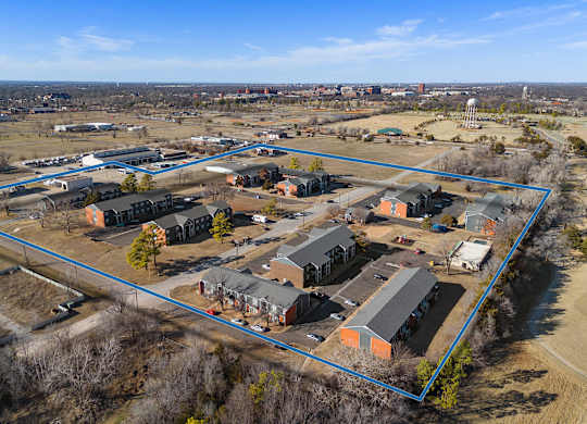 a birdseye view of a neighborhood of houses and a city in the background at Emerald Greens, Norman, 73072