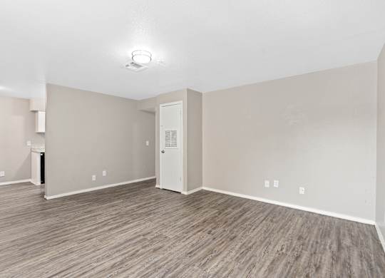 an empty room with white walls and a wood floor at Emerald Greens, Norman, 73072