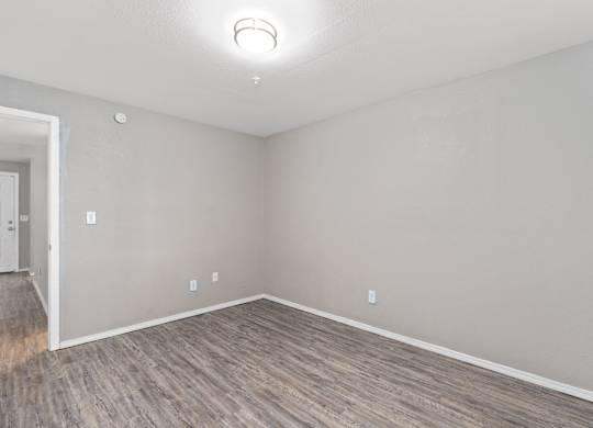 an empty living room with wood flooring and white walls at Emerald Greens, Oklahoma