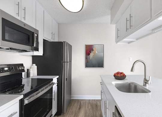 a kitchen with black appliances and white cabinets at Lakeside Villas, Florida