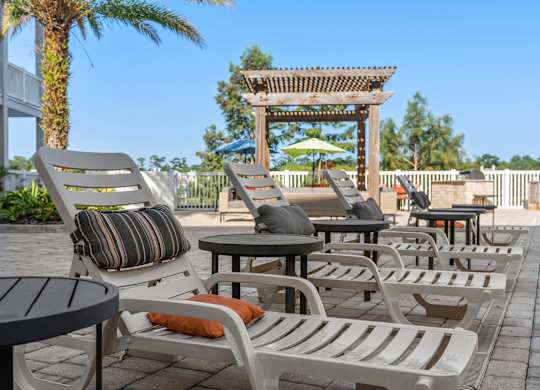 a group of lounge chairs and tables on a patio at Lake Lofts at Deerwood, Jacksonville, 32216