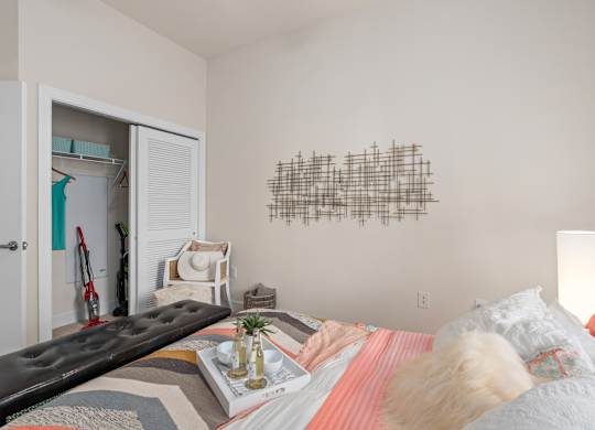 a bedroom with a bed and a white door to a closet at Lake Lofts at Deerwood, Jacksonville, Florida