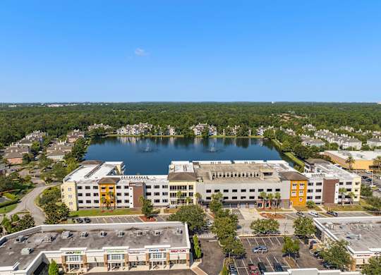an aerial view of a building next to a lake at Lake Lofts at Deerwood, Jacksonville