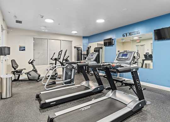 a gym with treadmills and other exercise equipment in a building at Lake Lofts at Deerwood, Jacksonville, FL