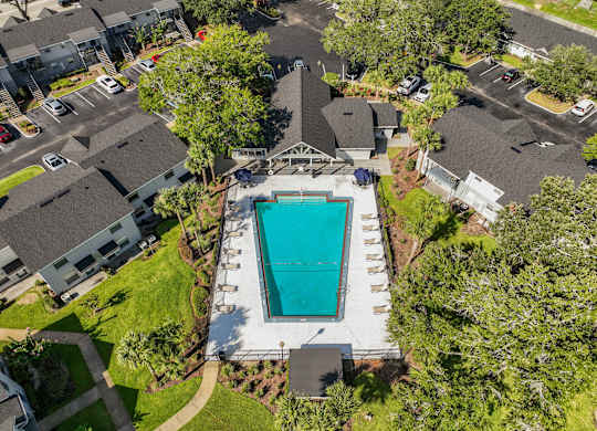 a birds eye view of a swimming pool in a neighborhood with houses and trees at Oak Reserve at Winter Park, Winter Park