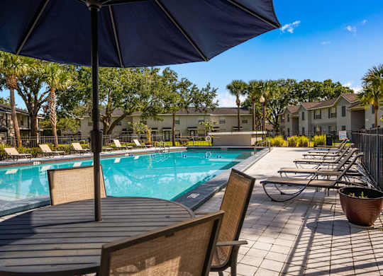 our apartments have a resort style pool with tables and chairs at Oak Reserve at Winter Park, Winter Park, Florida