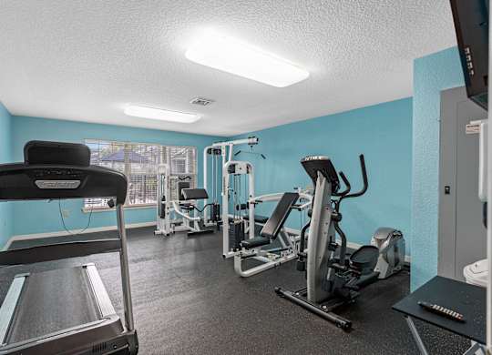 the gym has cardio machines and weights in it at the enclave at woodbridge apartments at Oak Reserve at Winter Park, Florida