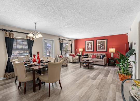 a living room and dining room with red walls and wooden floors at Oak Reserve at Winter Park, Winter Park, 32792