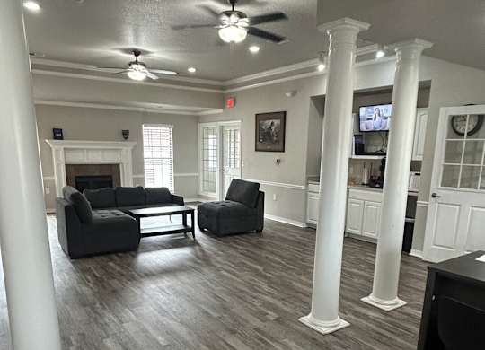 A living room with a grey couch and a wooden floor.at Chapel Ridge of Stillwater, Stillwater, 74075