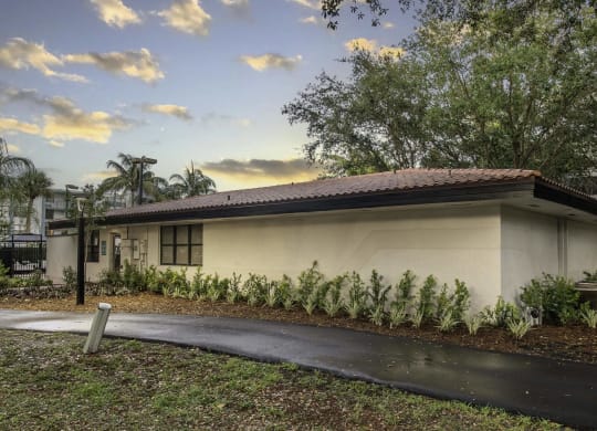 a house with a driveway and trees in the background  at Club at Emerald Waters, Hollywood, 33021