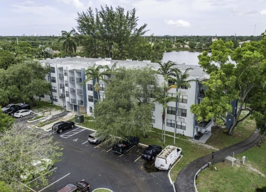 an aerial view of a large white apartment complex with a river in the background  at Club at Emerald Waters, Hollywood, 33021
