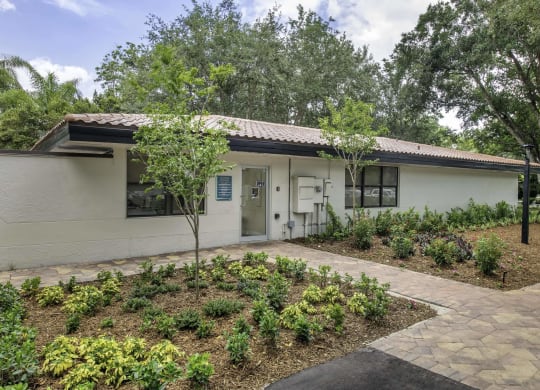 a white house with a garden in front of it  at Club at Emerald Waters, Hollywood, Florida