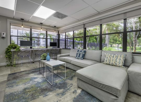 a living room with a couch and a coffee table in front of a wall of windows  at Club at Emerald Waters, Hollywood