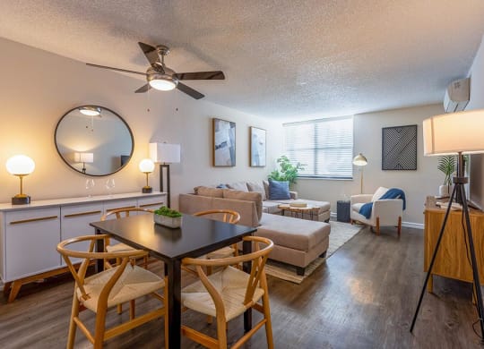 a living room and dining area with a ceiling fan and a large mirror  at Club at Emerald Waters, Hollywood, FL