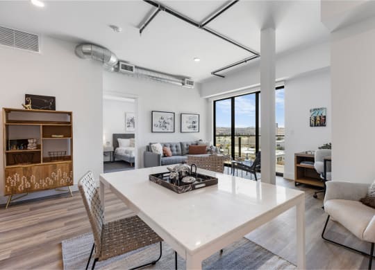 Dining room area with a white marble table and gray seating.