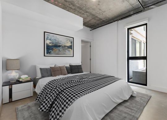 Bedroom with queen-sized bed, white bedding, and a black/white throw.