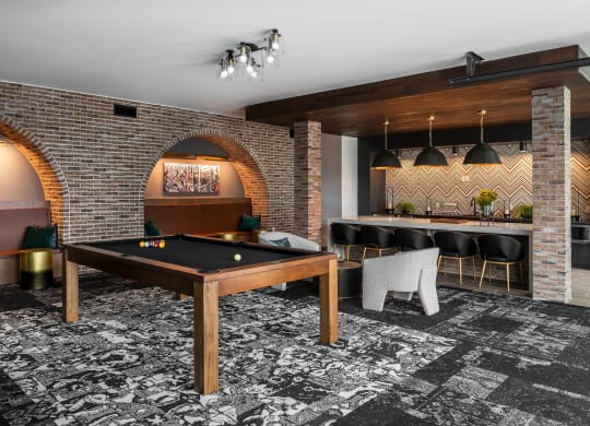 Modern resident clubroom with pool table and lounge kitchen  at Chapter at the Streets of St Charles, Saint Charles, MO, 63303