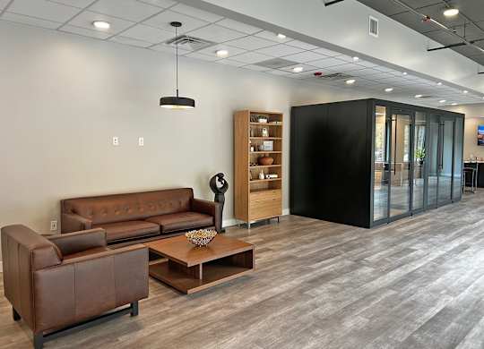 A modern living room with a brown leather sofa and a wooden coffee table.