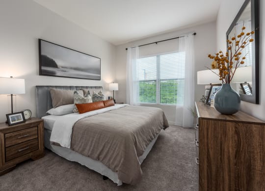 Modern bedroom with large window, dresser and nightstand  at Chapter at the Streets of St Charles, Saint Charles, 63303