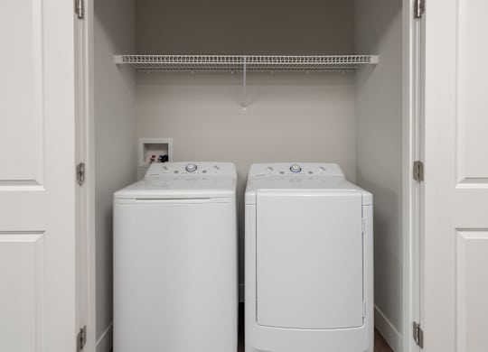 Two white front load washing machines in a laundry room.