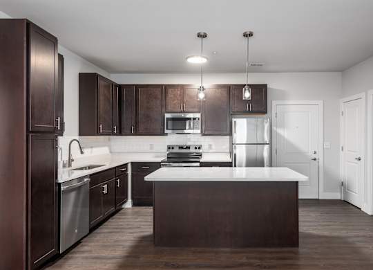 A modern kitchen with dark brown cabinets and a white countertop.