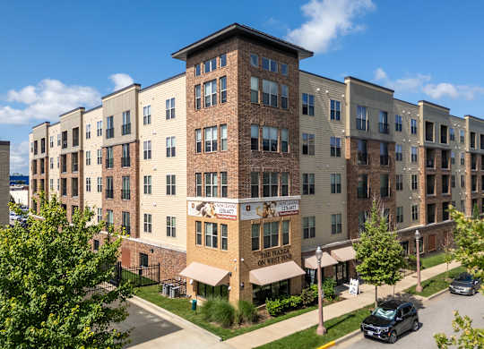 A large apartment complex with a parking lot in front.