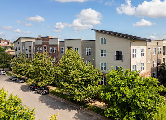 A row of townhouses with trees in front of them.