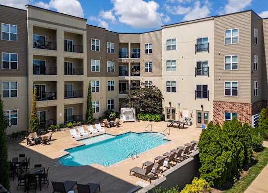 A large apartment complex with a pool in the courtyard.