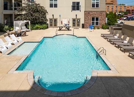 A large rectangular pool with a concrete floor and a concrete wall surrounding it.