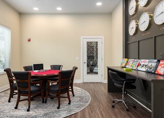 A conference room with a table and chairs and a wall of clocks.