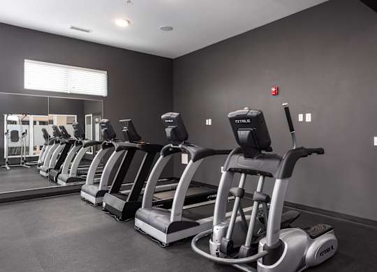 A gym with treadmills lined up.