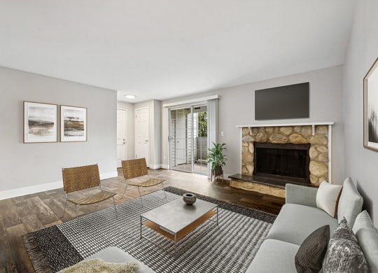Model Living Room with Wood-Style Flooring, a Fireplace and Patio Accessibility at Central Flats Apartments in Kent, WA.