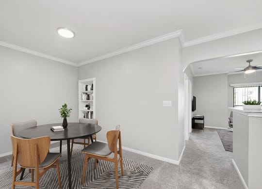 Model Dining Room with Carpet and View of Living Room at Hidden Creek Apartments located in Lewisville, TX.