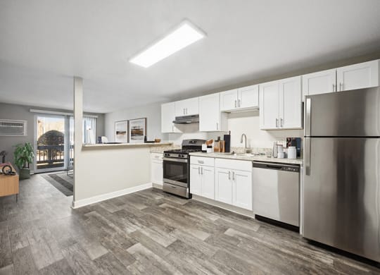 Model Kitchen with White Cabinets and Wood-Style Flooring at Middlesex Crossing Apartments in Billerica, MA.