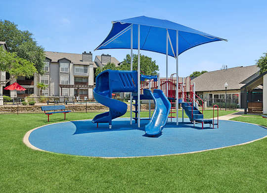 Community Playground with Two Slides at Cobblestone Apartments located in Arlington, TX.