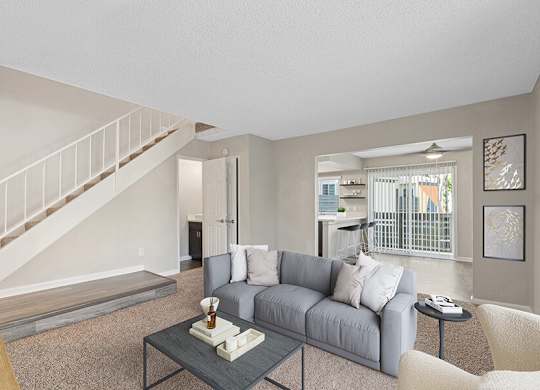 Model Living Room with Carpet and View of Kitchen at Horizon Apartments located in Santa Ana, CA.