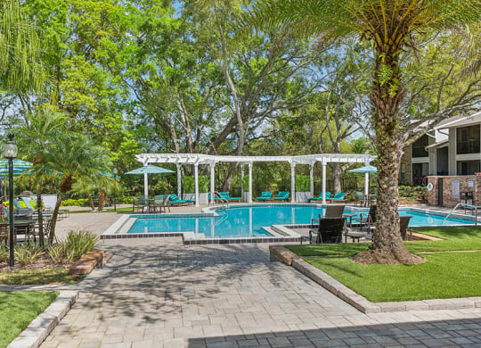 Community Swimming Pool with Pool Furniture at Grand Pavilion Apartments in Tampa, FL.