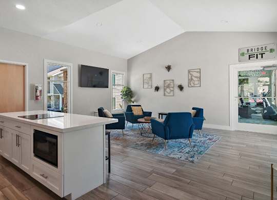 Community Clubhouse with Lounge Furniture and Kitchenette Area at Broadmoor Village Apartments located in West Jordan, UT.