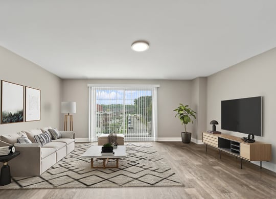 Model Living Room with Wood-Style Flooring and Patio Accessibility at Heights at Marlborough Apartments located in Marlborough, MA.