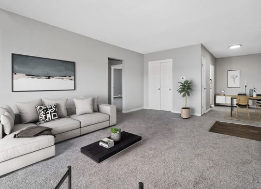 Model Living Room with Carpet and View of Dining Room at Stone Ends Apartments in Stoughton, MA.
