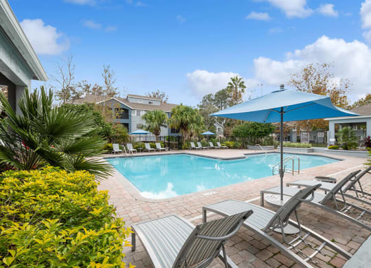 Community Swimming Pool with Pool Furniture at Westland Park Apartments in Jacksonville, FL.
