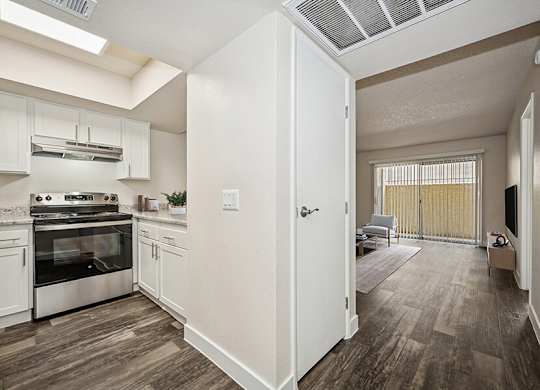 Model Kitchen with White Cabinets and Wood-Style Flooring at Butler Ridge Apartments located in Glendale, AZ.