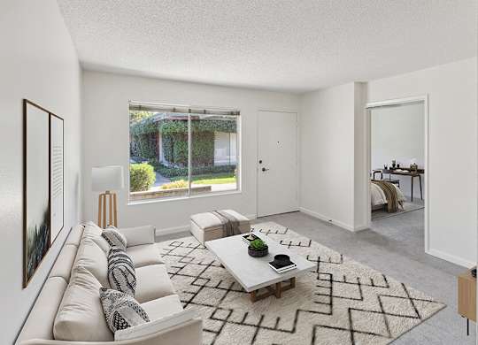 Model Living Room with Carpet and Window View at Walnut Creek Apartments located in Walnut Creek, CA.