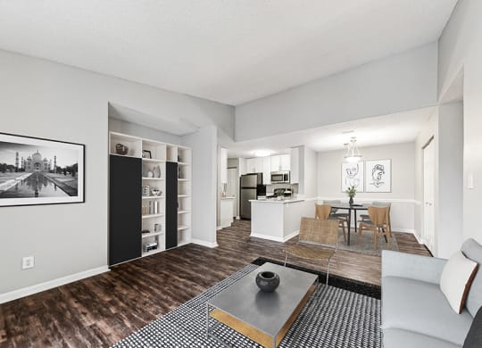 Model Living Room with Wood-Style Flooring and View of Kitchen/Dining Area at Commons at Haynes Farm Apartments in Shrewsbury, MA.