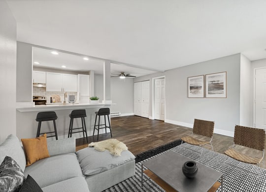 Model Living Room with Wood-Style Flooring and View of Kitchen at Central Flats Apartments in Kent, WA.