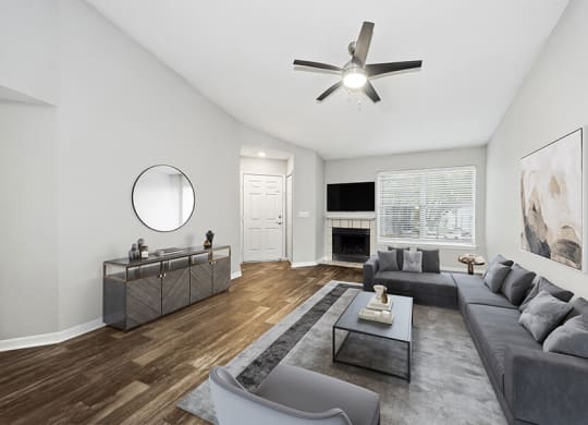 Model Living Room with Wood-Style Flooring and Fireplace at Retreat at Crosstown Apartments in Riverview, FL.