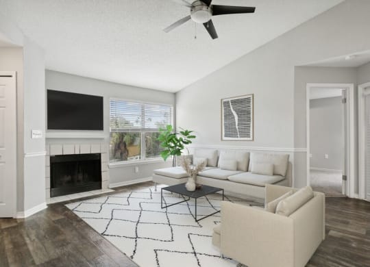 Model living room with fireplace and ceiling fan