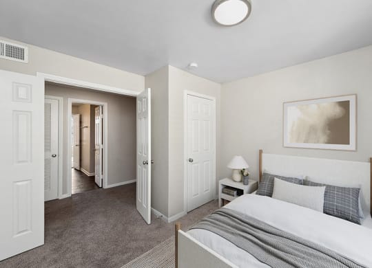 Model Bedroom with Carpet and Hallway View at Hidden Creek Apartments in Lewisville, TX.
